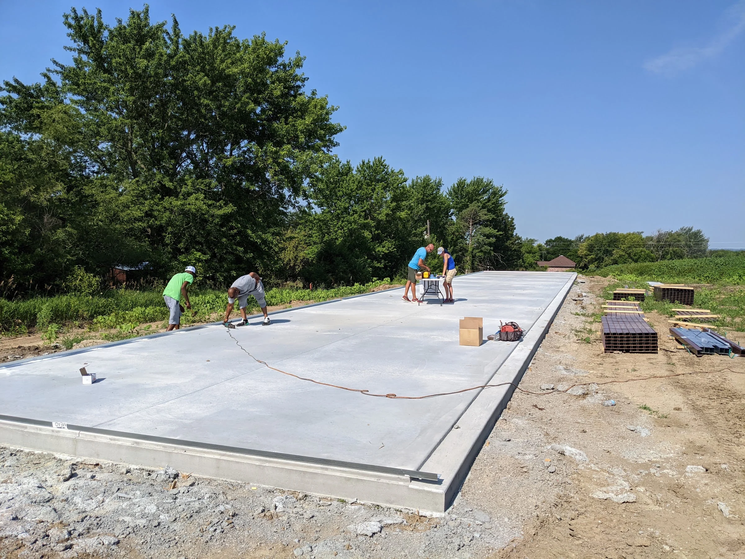Crew finishing a new concrete slab for a storage building