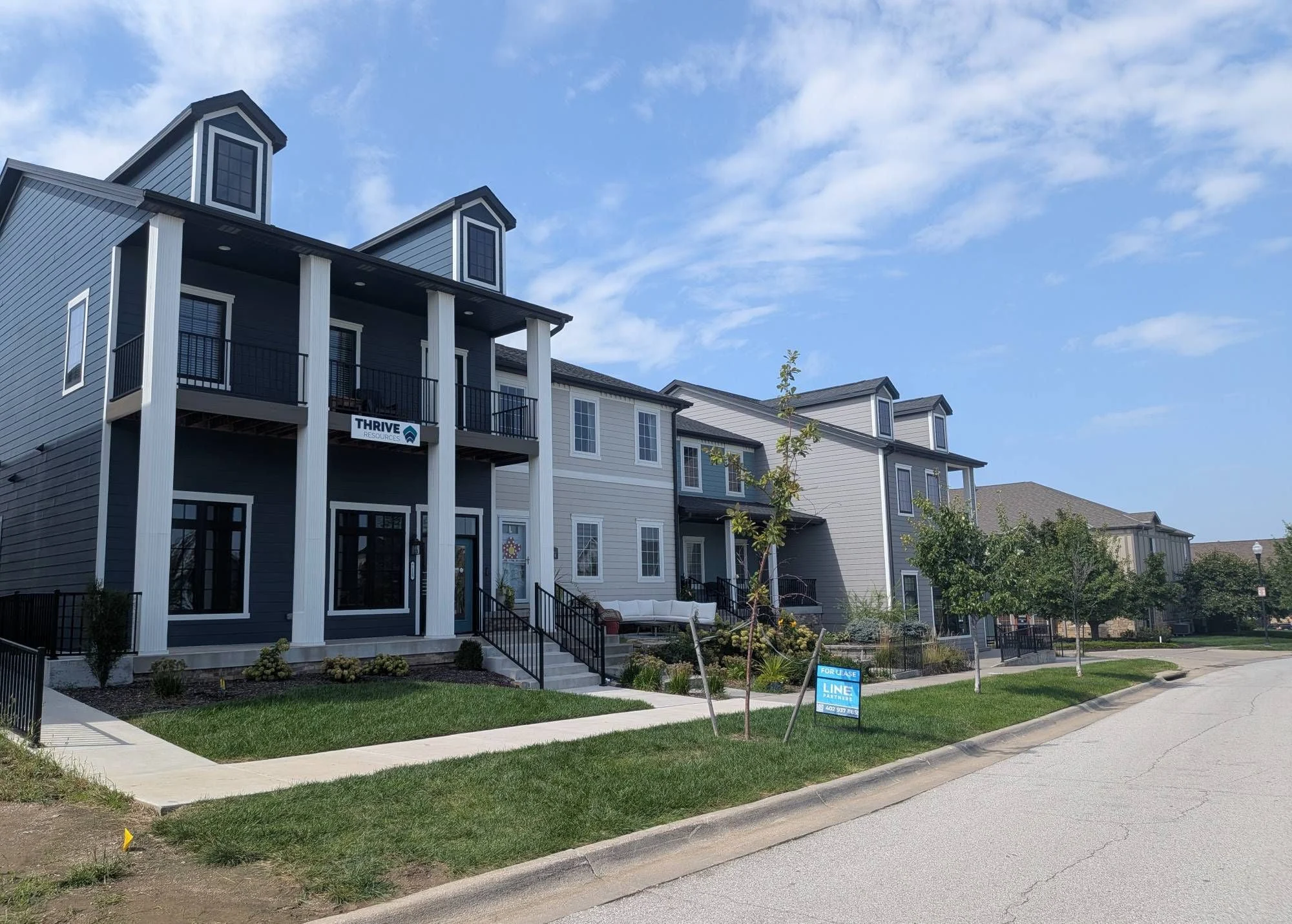 Live/work end unit with a two-story columned porch, ground-floor office space, and apartments above