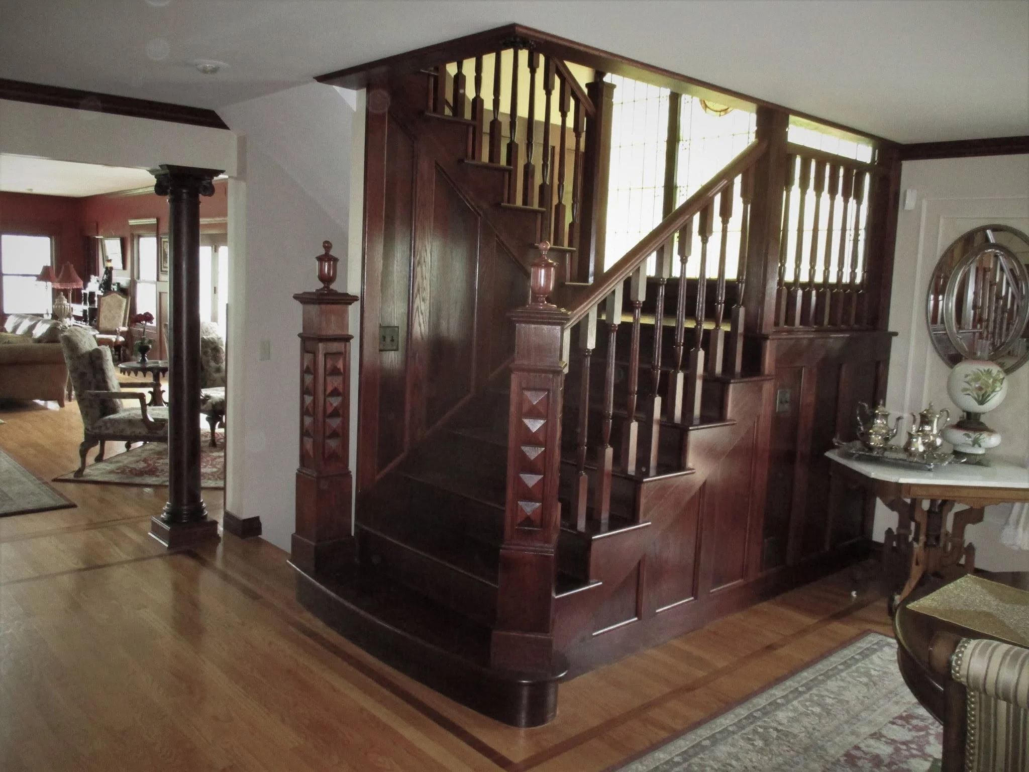 Dark-stained wood staircase with turned balusters and a carved newel post