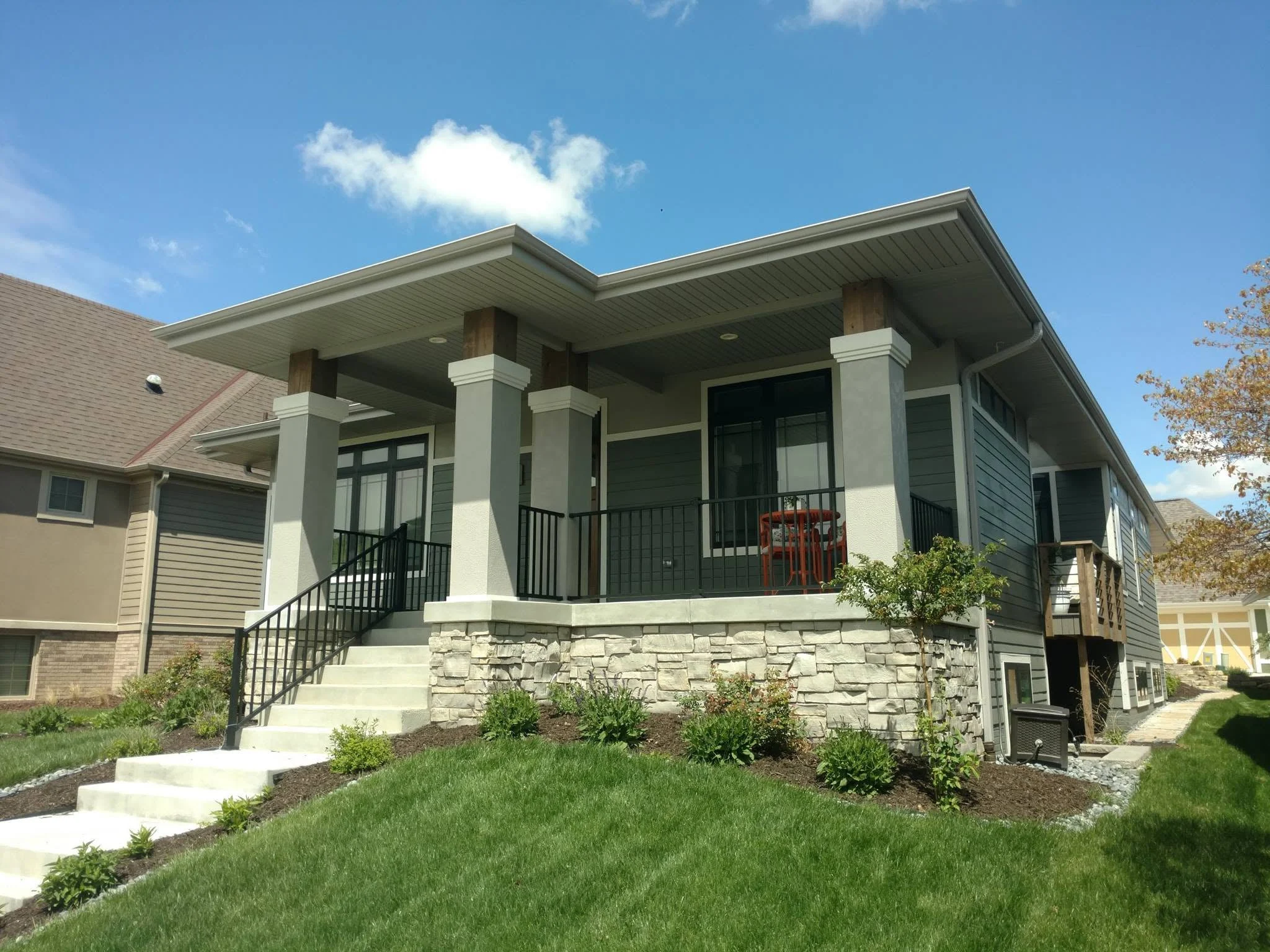 Craftsman-style home with stone accents and a wraparound porch