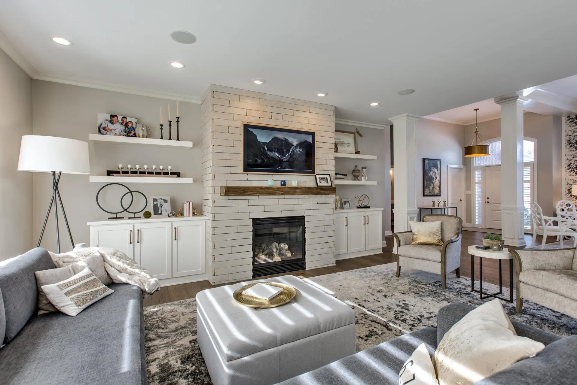 Living room with a stone fireplace flanked by built-in shelves