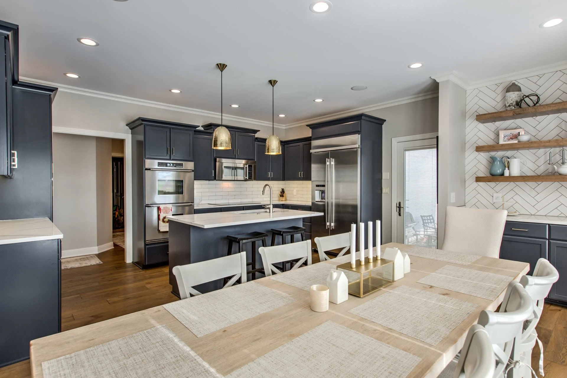 Open kitchen and dining area with a long farmhouse table and open shelving