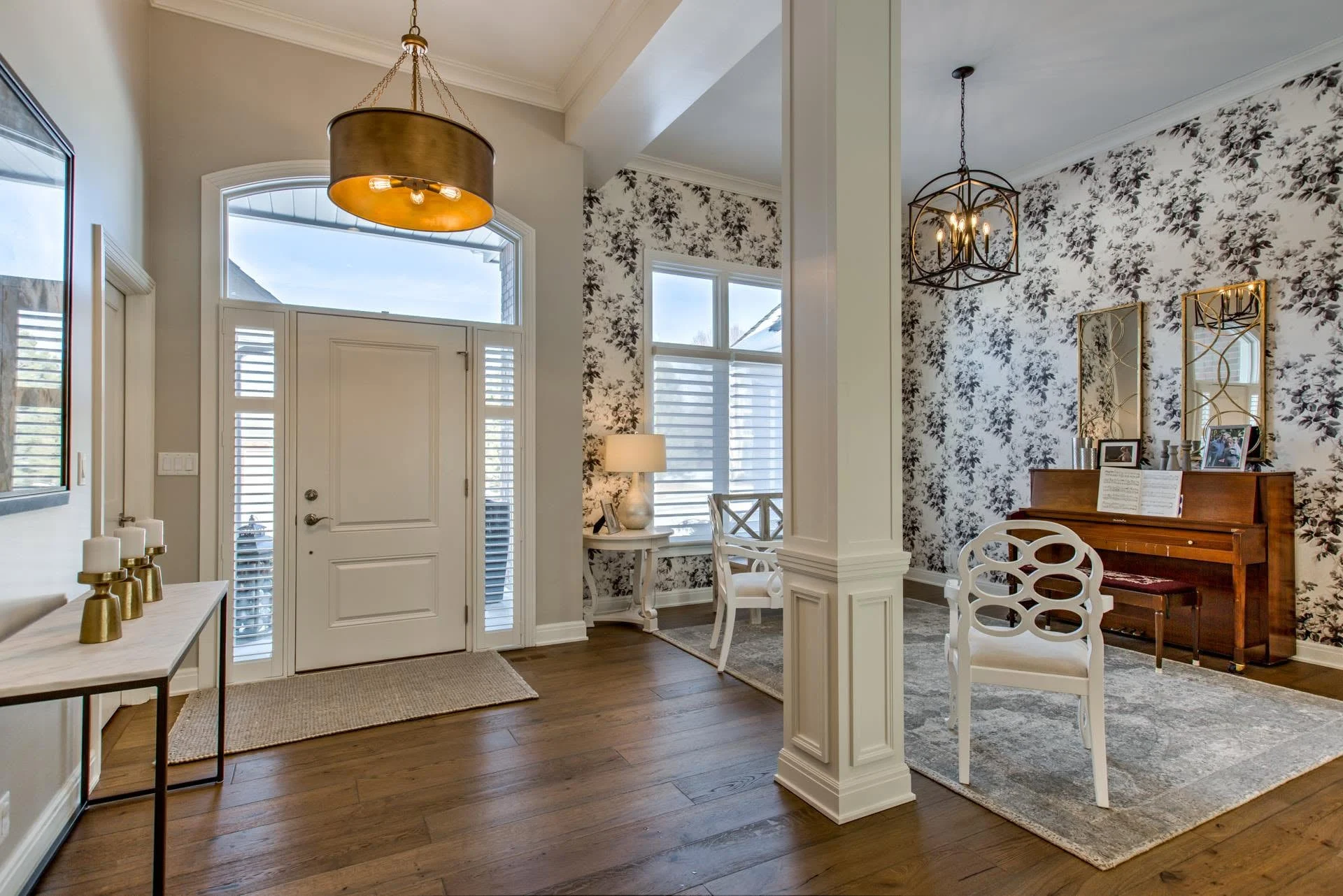 Entry with an arched transom window, square columns, and a brass pendant