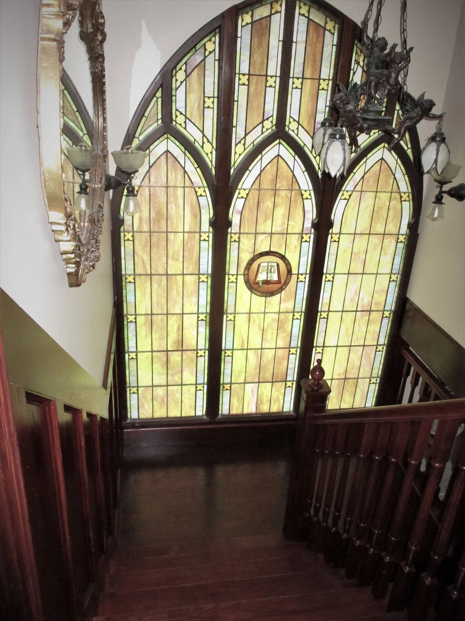Stair landing with an arched stained-glass window