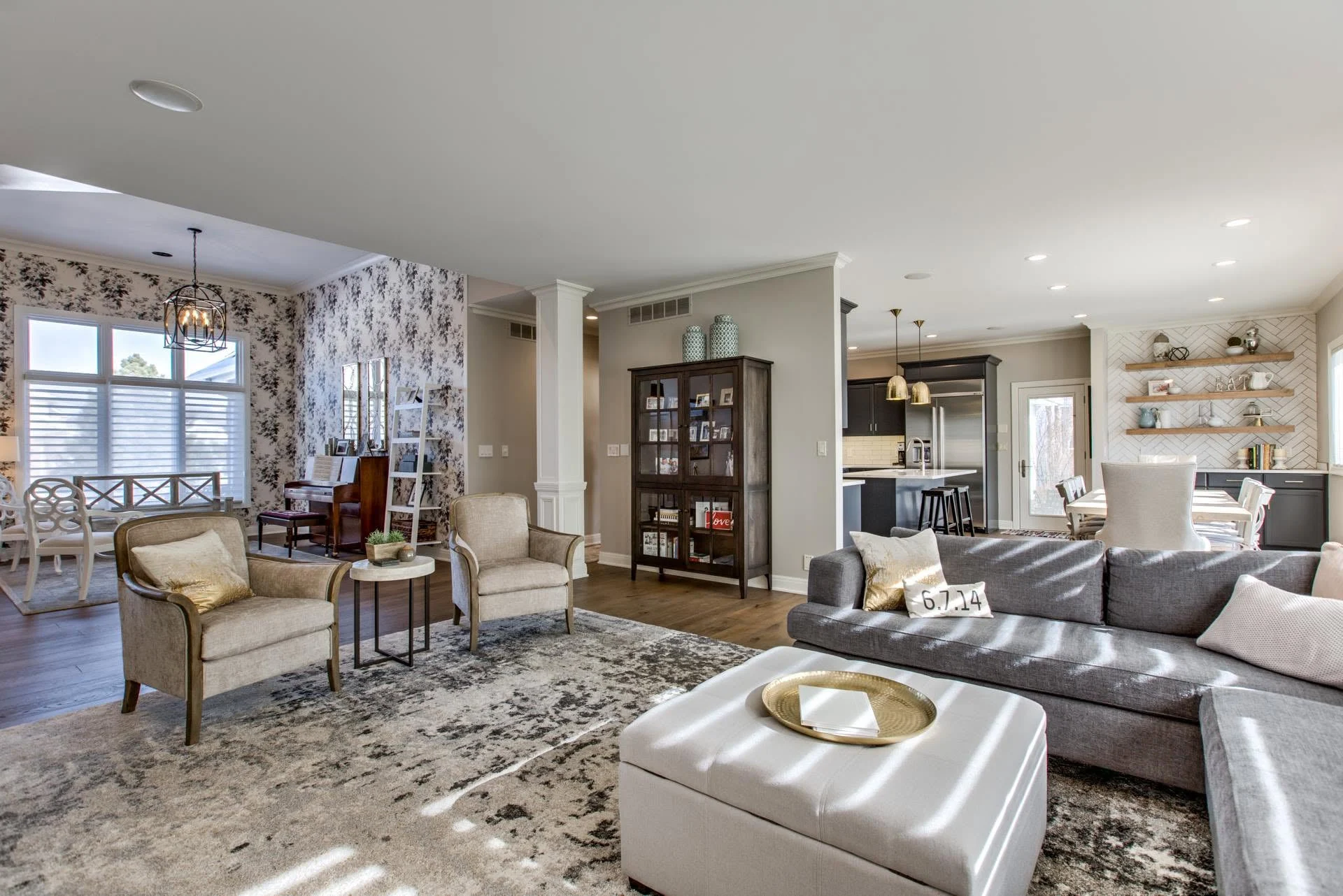 Bright living room with patterned wallpaper and large windows