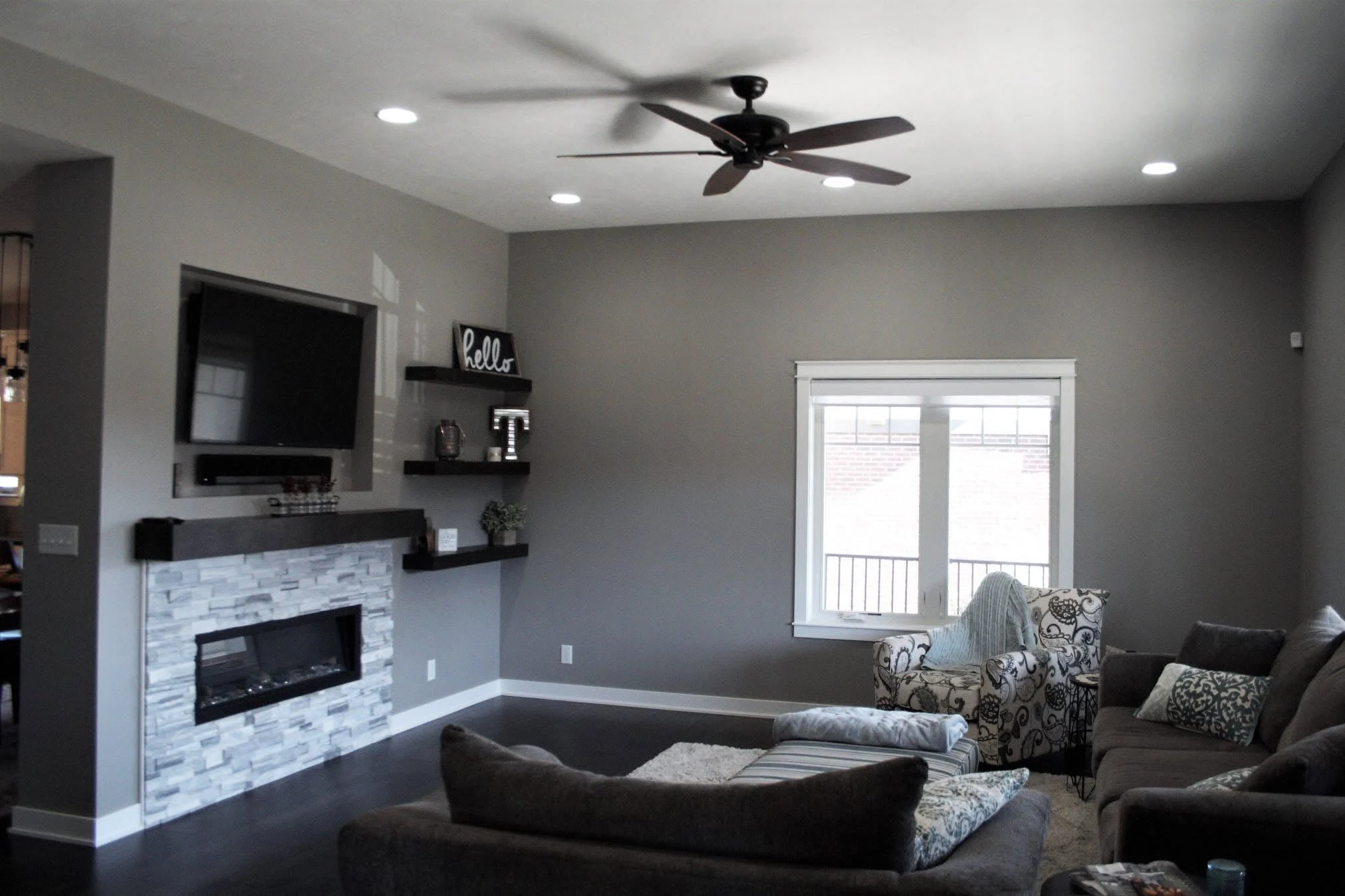 Living room with a linear fireplace and floating shelves